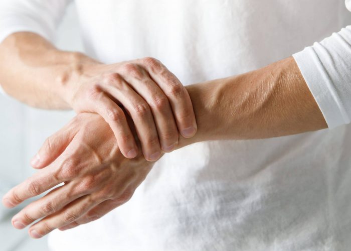 Closeup,Of,Male,Arms,Holding,His,Painful,Wrist,Caused,By